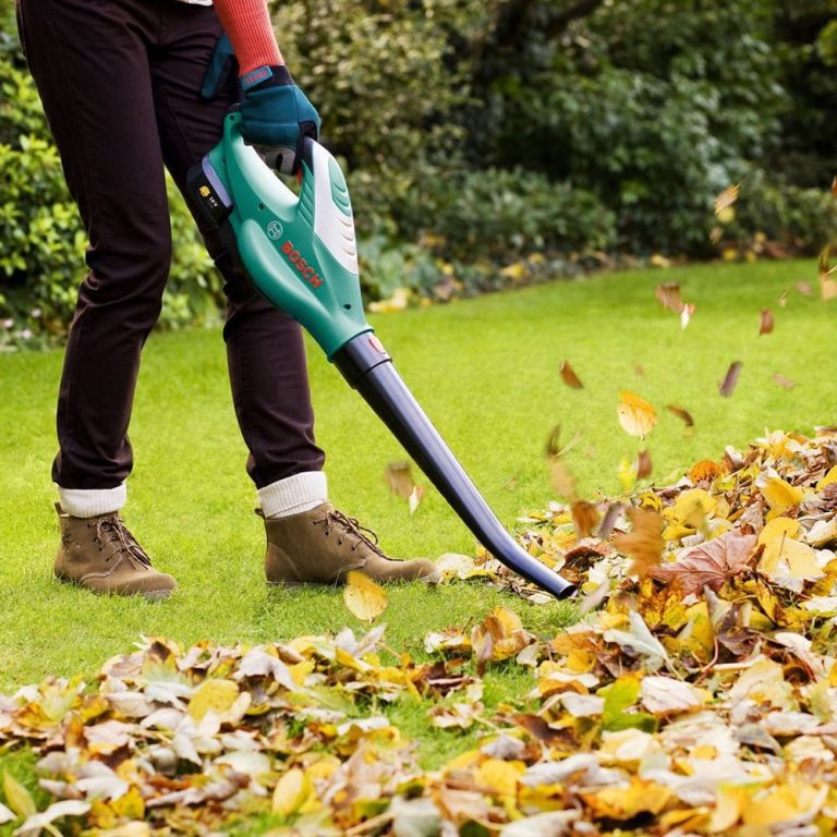 دمنده مکنده بوش در حال جارو کردن برگ های خشک درختان